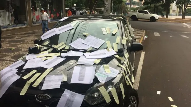 Empresária fica revoltada com multas e cola no carro dezenas de notificações de trânsito