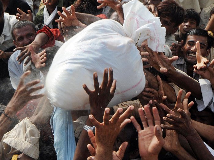 Sobreviventes das enchentes no Paquistão recebem suprimentos em Kot Addu, uma das cidades afetadas pelas chuvas