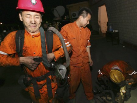 Trabalhadores de resgate retiram equipamento em frente à minha explodiu no último sábado (16), na China; ao menos 31 pessoas morreram no acidente