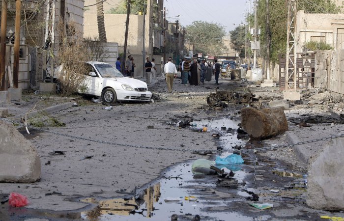Iraquianos examinam exterior de igreja católica atacada por insurgentes em Bagdá neste domingo (31)