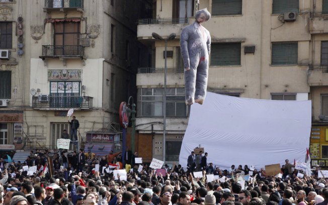 Uma efígie do presidente egípcio, Hosni Mubarak, é vista sobre os manifestantes na Praça Tahrir (ou Libertação) no Cairo