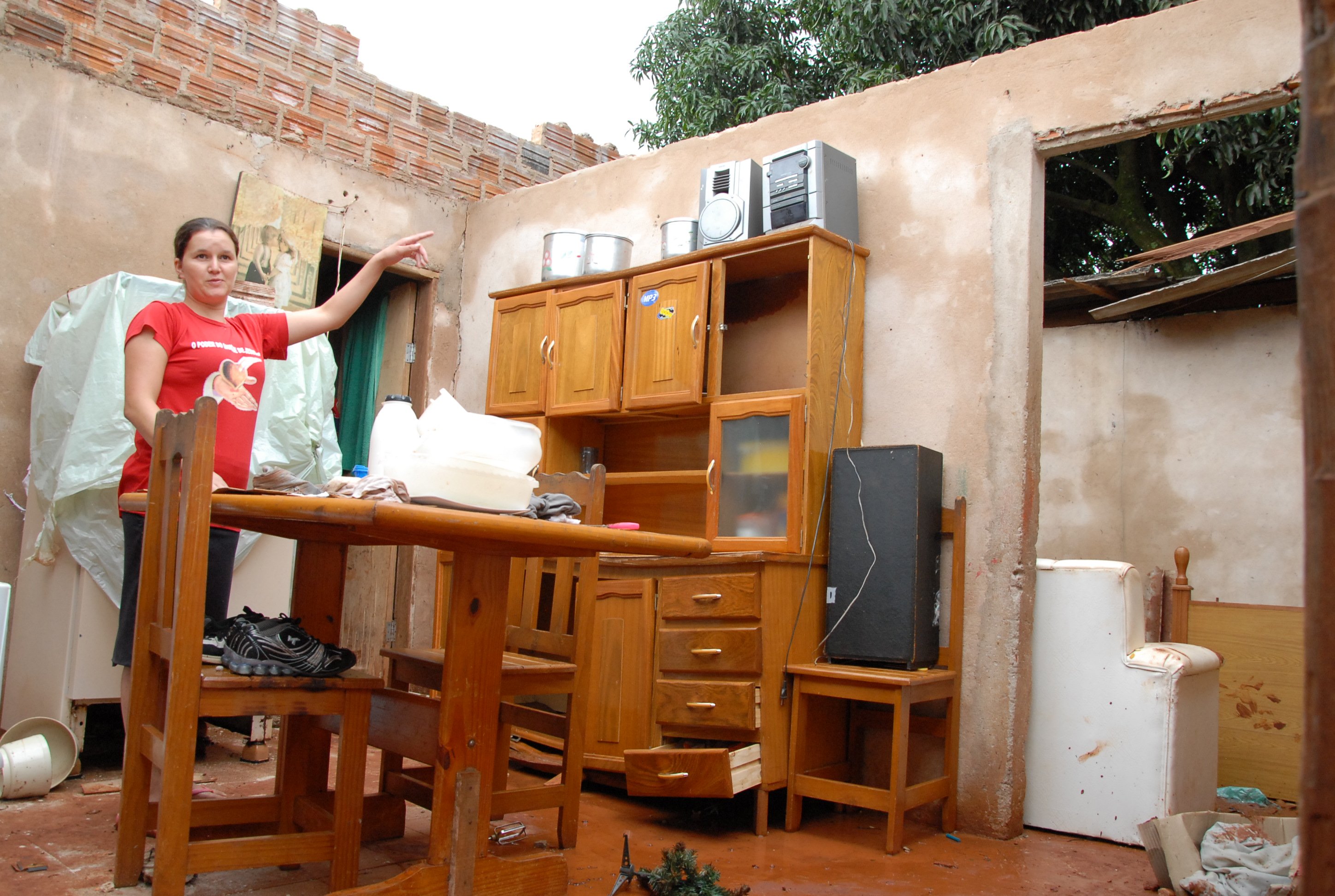 Moradora Andréia Nadaluti mostra a casa da cunhada, nos fundos da sua: chuva destruiu tudo