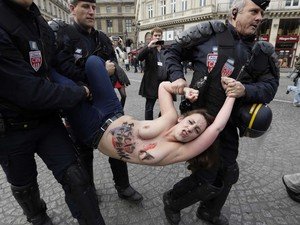 Policiais usam a força para retirar ativista do Femen durante festa do Dia do Trabalho em Paris (Foto: Kenzo Tribouillard / AFP Photo)