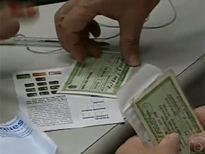 Eleitor com título durante atendimento em cartório (Foto: Reprodução / TV Globo)