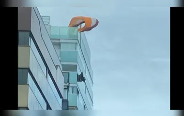 Homem fica preso em parapente no topo de prédio