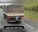 Passageiro é flagrado sentado em para-choque de caminhão