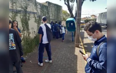 Estudante Flávio Pereira de Miranda usa celular ao lado de orelhão em Apucarana