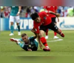 (Joshua Kimmich e Go Yo-han disputam lance e vão ao chão em partida dominada pela Alemanha, mas vencida pela Coreia (SERGEY DOLZHENKO / EFE/ Direitos Reservados)